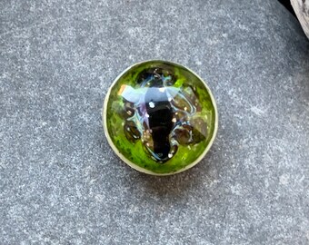 Glittery mottled green lampwork glass dragon eye cabochon. Perfect for silversmithing, polymer clay or beading projects