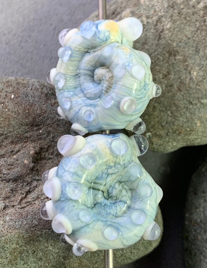 Streaky cream and blue ammonite lampwork bead pair