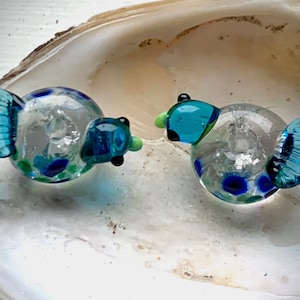 Transparent lampwork bird bead pair with turquoise head and tail