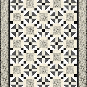 May include: A rectangular quilt with a repeating geometric pattern. The quilt features a black border and a cream-colored background. The pattern includes black squares, gray triangles, and squares with a newspaper-like print. The border has a cream-colored print.