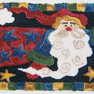 Könnte beinhalten: Handgeknüpfter Weihnachts-Teppich mit Weihnachtsmann mit weißem Bart und roter Mütze. Der Teppich hat einen schwarzen Hintergrund mit blauen Sternen, goldenen Sternen und einem farbenfrohen Rand. Eine festliche Weihnachtsdekoration.
