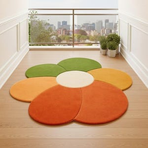 May include: A colorful, flower-shaped rug with a cream-colored center and petals in shades of orange, yellow, and green. The rug is placed on a light-colored wooden floor, with a city skyline visible in the background.