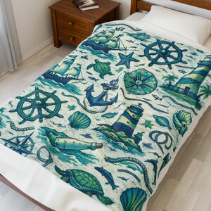 Puede incluir: Una manta de temática náutica con ilustraciones de barcos, anclas, faros y criaturas marinas en tonos azules y verdes. El diseño incluye un timón, una brújula y conchas marinas, creando una estética costera. La manta está sobre una cama.