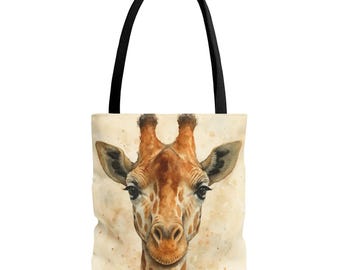 May include: Tote bag featuring a watercolor illustration of a giraffe's face. The giraffe has brown and tan fur with dark eyes and ears. The bag has a black handle and a cream-colored background.