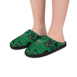 Op de afbeelding: Groene en zwarte slippers met poolthema. De slippers hebben een herhalend patroon van pooltafels, biljartballen en keuen op een groene achtergrond. De slippers hebben een zwarte zool en een zacht, comfortabel ontwerp.
