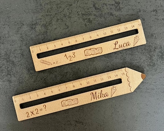 May include: Two wooden rulers with engraved designs. One ruler is rectangular and the other is shaped like a pencil. Both have measurements in inches, the text "123", "ABC", and the name "Luca" on one, and "2x2=?", "ABC", and "Mika" on the other.