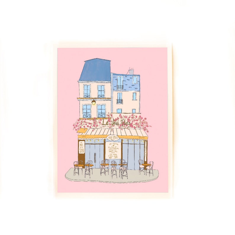May include: A pink illustration of a Parisian cafe with a blue and white building, a yellow awning, and the text "Le Vrai Paris". The cafe has tables and chairs outside.
