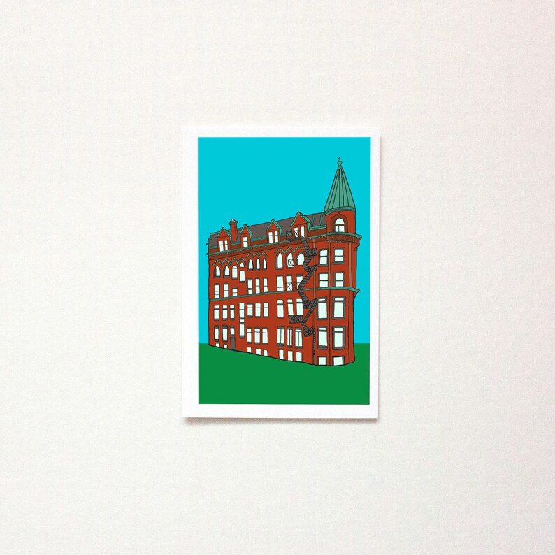 May include: A red brick building with a green roof and a tower. The building has many windows and a fire escape. The building is set against a blue sky.