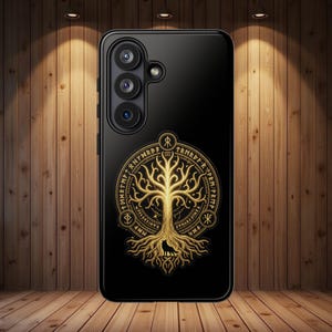 Könnte beinhalten: Schwarze Smartphone-Hülle mit einem goldenen Baumdesign, das detaillierte Wurzeln und Äste aufweist, umgeben von einem mit Runen beschrifteten Rahmen. Die Hülle hat eine Dreifach-Objektiv-Kamera.