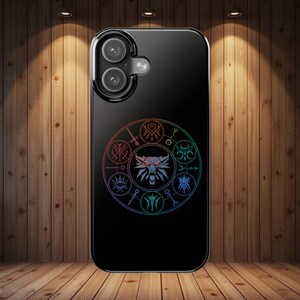 May include: Black phone case featuring a circular design with a wolf head and various symbols in a rainbow gradient. The case has a glossy finish and a dual-camera cutout.