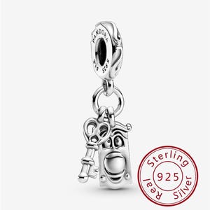 Può includere: Un charm in argento con un design a chiave e porta. Il charm è attaccato a una perlina del marchio Pandora. Il charm è realizzato in argento sterling, come indicato dal timbro "Sterling 925 Real Silver".