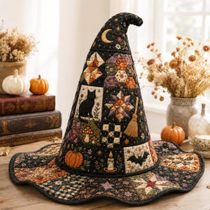 May include: A quilted witch hat featuring a patchwork design with black, orange, and purple fabric squares. The hat displays embroidered motifs including a black cat, a pumpkin, a bat, a broom, a candle, mushrooms, stars, and a crescent moon.