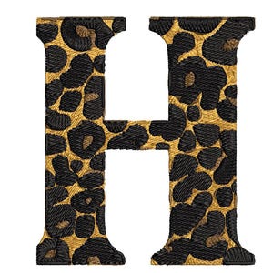 May include: Embroidered letter "H" with a leopard print design. The letter features a gold background with black spots, creating a textured appearance. The design is suitable for various craft projects.