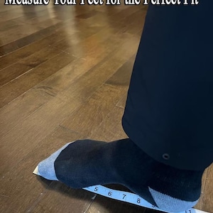 Pu&ograve; includere: Un piede con una calza nera e grigia posizionato su un metro a nastro bianco che mostra i pollici, con il testo Measure Your Feet for the Perfect Fit in alto. Il piede &egrave; appoggiato su una superficie di legno scuro.