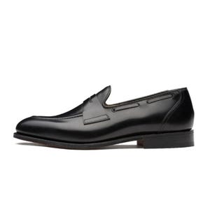 May include: A single black leather loafer shoe. The shoe has a sleek, polished appearance with a low heel and a decorative strap across the vamp. The design is classic and suitable for formal or business attire.