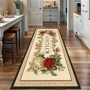 Peut inclure: Un tapis de cuisine rectangulaire à motifs floraux. Le tapis présente un fond crème avec une bordure rouge, verte et noire. Le mot "KITCHEN" est imprimé verticalement en noir. Le tapis est orné de roses rouges et crème.