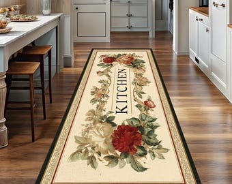 May include: A rectangular kitchen rug with a floral design. The rug features a cream-colored background with a border of red, green, and black. The word "KITCHEN" is vertically printed in black. The rug is decorated with red and cream-colored roses.