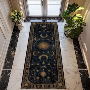 Pode incluir: Um tapete retangular azul escuro com um design celestial com um grande sol, luas crescentes e estrelas douradas. O tapete tem uma borda detalhada e é colocado em um corredor com piso de mármore e plantas.