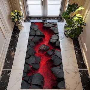 Puede incluir: Alfombra rectangular con un diseño de piedras negras agrietadas y un centro rojo vibrante, que recuerda a un flujo de lava. La alfombra está colocada sobre un suelo de baldosas de mármol, creando un contraste llamativo. Dimensiones no especificadas.