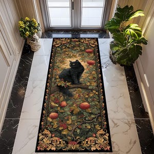 May include: A rectangular black floor mat featuring a black cat perched on a tree branch, surrounded by leaves, berries, and red fruit. The mat has an ornate border with gold accents, creating a decorative and artistic design.