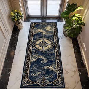 May include: A navy blue rectangular rug with a nautical design. The rug has a compass rose in the centre, surrounded by waves and a rope border. The top of the rug depicts a cloudy sky.