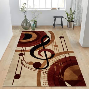 Könnte beinhalten: Ein rechteckiger Teppich mit musikalischem Thema. Der Teppich zeigt einen großen schwarzen Notenschlüssel und Noten in Braun-, Beige- und Schwarztönen auf cremefarbenem Hintergrund. Der Teppich liegt auf einem hellen Holzboden.