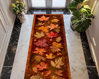 Puede incluir: Una alfombra rectangular con un diseño de hojas de otoño en tonos rojos, naranjas y amarillos. La alfombra tiene un fondo marrón oscuro y un borde a juego. La alfombra está colocada sobre un suelo de baldosas blancas y negras.