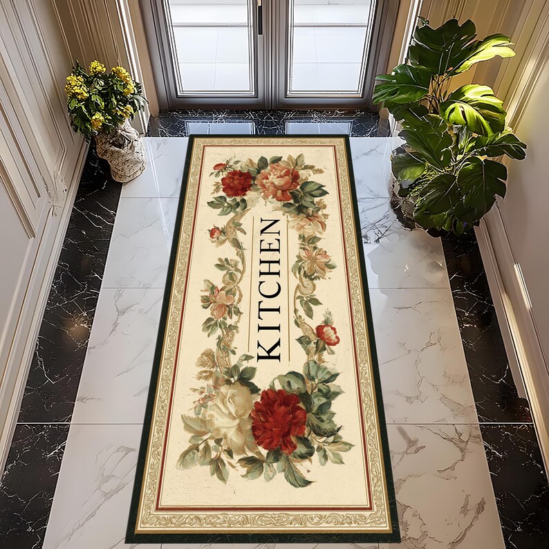 May include: Rectangular kitchen rug with a cream background, floral design, and the word "KITCHEN" in black. The rug features red, pink, and cream-colored roses and green leaves. The border is dark green with a red and gold trim.