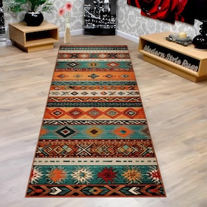 May include: A rectangular area rug with a Southwestern design. The rug features a repeating pattern of geometric shapes in shades of teal, orange, brown, and cream. The rug is made of a durable material and is suitable for high-traffic areas.