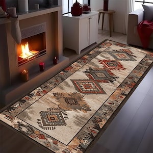 May include: A rectangular area rug with an intricate geometric pattern in shades of beige, gray, red, and brown. The rug features a central design of diamond and tribal motifs, bordered by a darker brown edge. The rug is placed in front of a fireplace.
