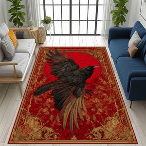 May include: A rectangular red area rug featuring a large black raven with outstretched wings against a red sun. The rug has a detailed floral and ornamental border in gold and red tones, creating a striking visual contrast.
