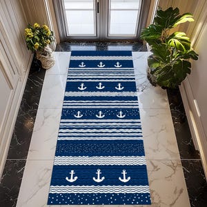 Puede incluir: Una alfombra de pasillo de color azul marino y blanco con temática náutica. La alfombra presenta rayas blancas alternas, patrones de puntos y líneas onduladas. Anclas blancas están espaciadas uniformemente en la alfombra. La alfombra rectangular está diseñada para un pasillo o entrada.