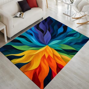 May include: A colorful area rug with a vibrant floral design. The rug features a spectrum of colors, including orange, yellow, green, blue, and purple, arranged in a radiating pattern. The rug is rectangular and appears to be made of a soft material.
