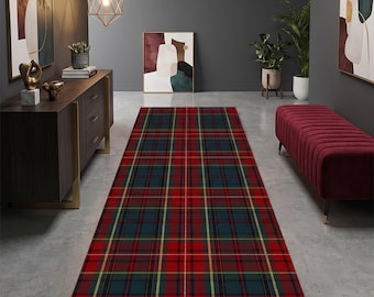 May include: A rectangular area rug featuring a traditional tartan plaid pattern in deep red, dark teal, and thin yellow lines. The rug is positioned centrally on a concrete floor, extending from the foreground toward the back of the room.