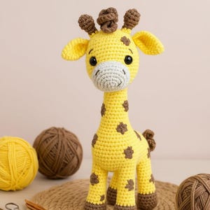 Może przedstawiać: Żółta szydełkowa żyrafa z brązowymi plamami, uszami i kopytami. Żyrafa ma biały pysk i brązowe rogi. Kłęby przędzy i szydełka w tle.