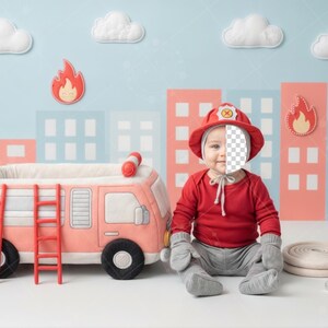 May include: A baby dressed as a firefighter sits in front of a toy fire truck. The baby wears a red hat and shirt, gray pants and gloves. A red fire hydrant and a rolled-up hose are nearby. The background features a city scene.