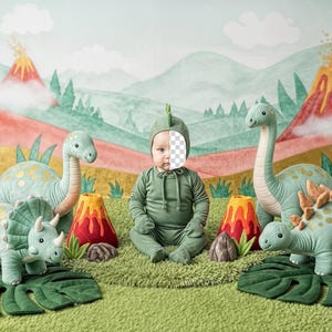 Puede incluir: Un bebé con un disfraz de dinosaurio verde está rodeado de peluches de dinosaurios y decoraciones de volcanes. El fondo presenta un paisaje pintado con volcanes y montañas. La escena está sobre una alfombra verde.