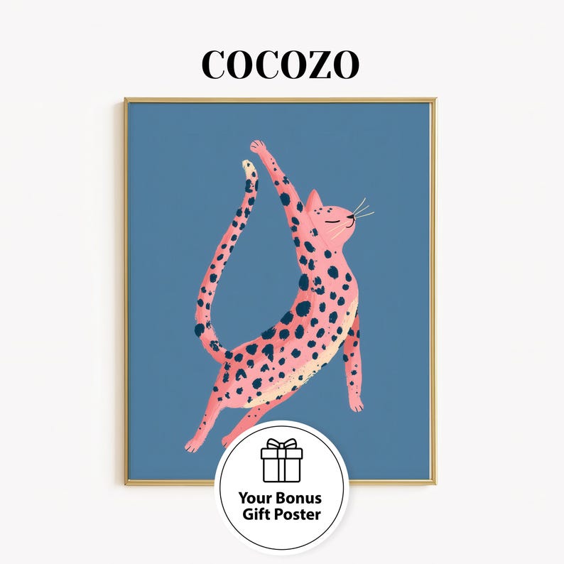 May include: A framed art print featuring a pink cat with black spots, stretching upwards against a blue background. The word "COCOZO" is at the top. A bonus gift poster is included.