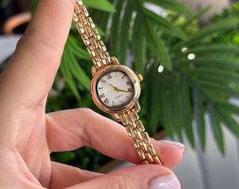 Reloj dorado para mujer, con números romanos clásicos y elegante pulsera de cuarzo.