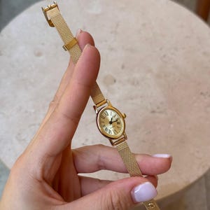 Reloj ovalado dorado con números romanos y brazalete de malla. Elegante reloj de pulsera clásico de cuarzo para mujer.