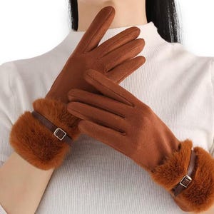Peut inclure: Gants bruns avec poignets en fausse fourrure et détail boucle. Les gants sont de couleur marron uni et semblent être faits d'une matière douce. Les poignets ont une bande de similicuir marron avec une petite boucle.