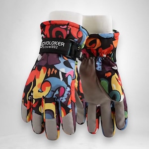 May include: A pair of colorful winter gloves with a vibrant abstract pattern in red, blue, yellow, and purple. The gloves have gray palms and cuffs, and the brand name "VOLOKER since1992" is printed on the strap.