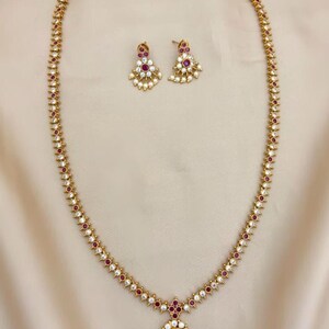 Traditional long haram design with gold plating, ruby stones, and pearl drops Necklace
