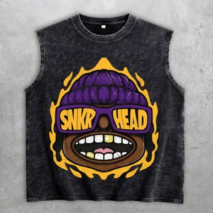 Könnte beinhalten: Ein ärmelloses, dunkelgraues T-Shirt mit einer Grafik eines Cartoon-Gesichts, das eine lila Mütze und eine Sonnenbrille trägt. Auf der Sonnenbrille steht "SNKRP HEAD" in gelben Buchstaben. Die Grafik ist gelb umrandet.