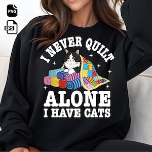 Könnte beinhalten: Schwarzes Sweatshirt mit dem Text "I NEVER QUIT ALONE I HAVE CATS". Die Grafik zeigt eine schwarz-weiße Katze auf bunten, gerollten Quilts unter einem Patchwork-Quilt. Das Design enthält Sterne.