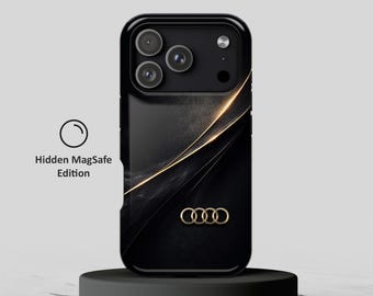 May include: A black smartphone case featuring a gold Audi logo and a diagonal gold light streak design. The case has a triple camera cutout and includes the text Hidden MagSafe Edition with a circular icon next to the phone case.