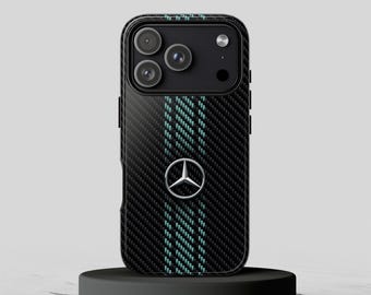 May include: A black carbon fiber textured smartphone case featuring a vertical teal stripe pattern running down the center and a silver Mercedes-Benz logo emblem centered on the back. The case includes a cutout for a triple camera lens array.