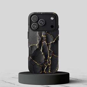 May include: Black phone case with a gold cracked marble design. The case has a glossy finish and a black camera module. The phone case is displayed on a black circular stand.