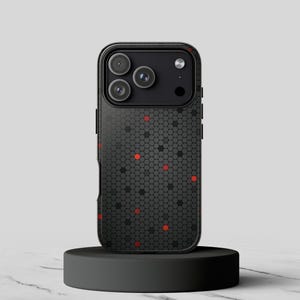 Op de afbeelding: Een smartphonehoesje met een donkergrijs en zwart zeshoekig honingraatpatroon op de achterkant. Het ontwerp bevat verspreide, felrode zeshoekige accenten door het hele raster. Het cameramodulegedeelte is zwart met drie ronde lenzen.