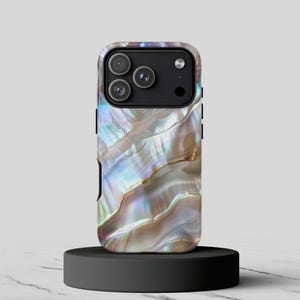 May include: A smartphone case with a pearlescent, iridescent design. The case features a swirling pattern of colors, including blues, greens, and browns, resembling the inside of a seashell. The case has a black camera module with three lenses.